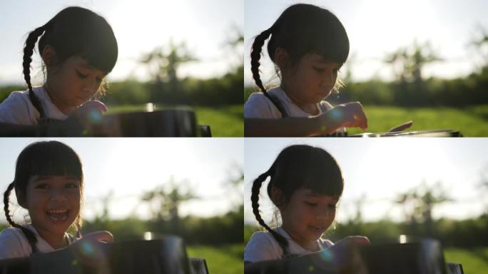 背光镜头，可爱的女孩在草坪上用吉他快乐地笑