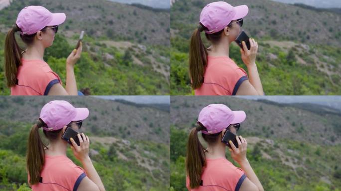 大自然中的徒步旅行者女孩在打电话。坐在风景优美的岩石上休息一下。