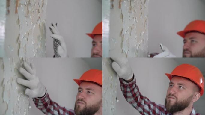 工人从墙上清除旧油漆。油漆剥落的房子墙。油漆正在剥落。房屋装修内部更新