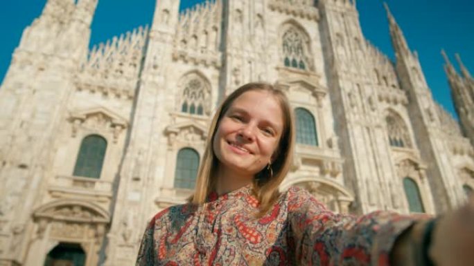 女人通过意大利地标性米兰大教堂的智能手机拍照或录像