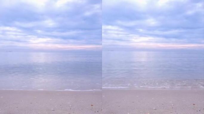 小波，软波在沙滩上打开视频，文字空间垂直。白色沙滩，沙滩上的海浪。