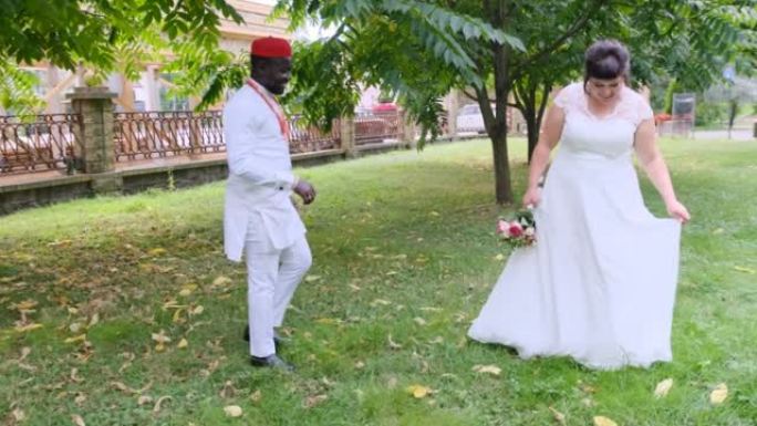 非洲新郎和高加索新娘跨种族婚礼的婚礼步行