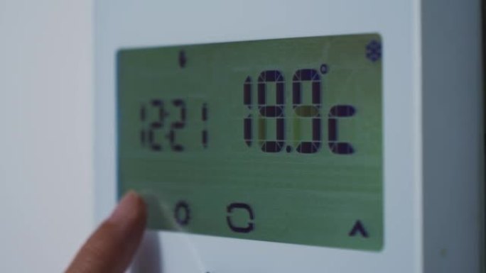 家庭恒温器设置。摄氏等级。用手降低房子的温度。至20摄氏度