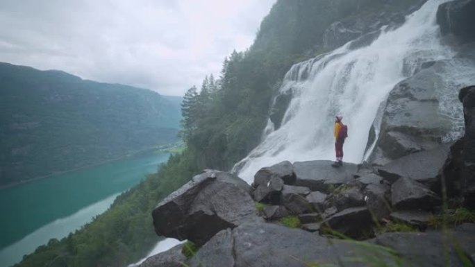 挪威山区瀑布附近的女人徒步旅行