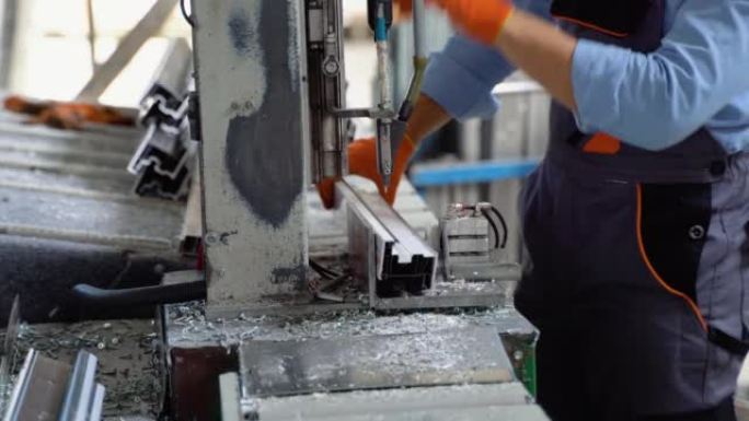 体力劳动者在一家工厂工作，他正在组装PVC门窗。铝和聚氯乙烯门窗生产