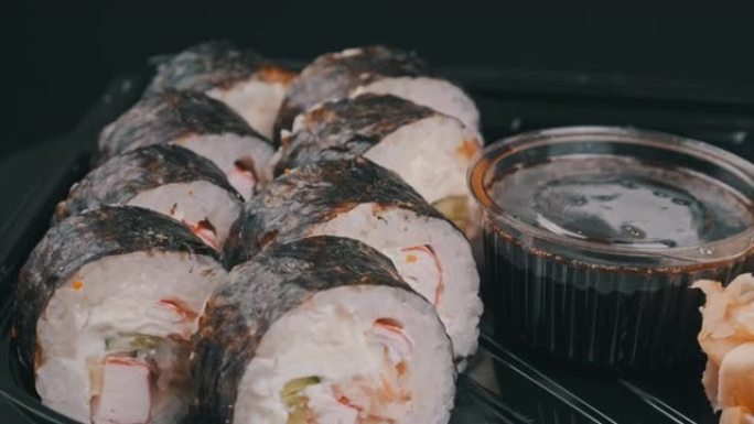 塑料盒中的日本寿司卷正在旋转