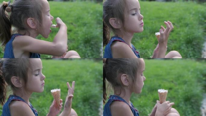 年轻可爱的白人女孩吃冰淇淋，孩子享受冰淇淋，拿着一个冰淇淋蛋卷，吃了一口甜点