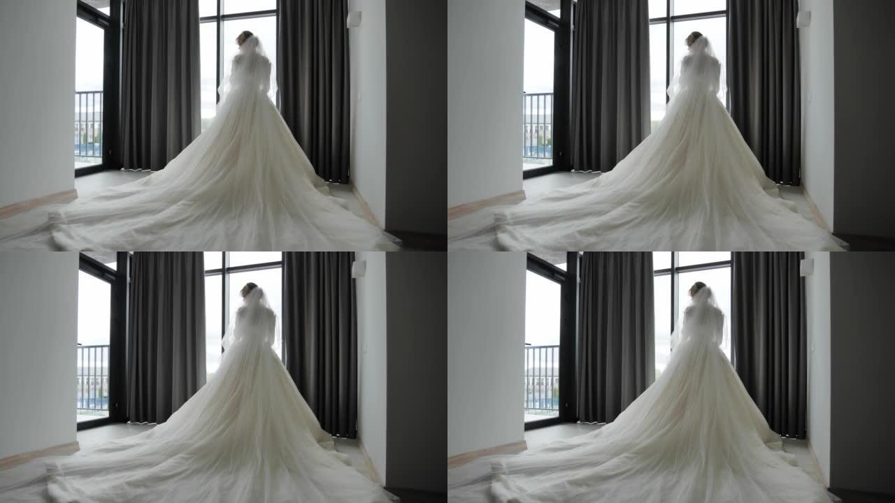 新娘穿着豪华婚纱站在窗边