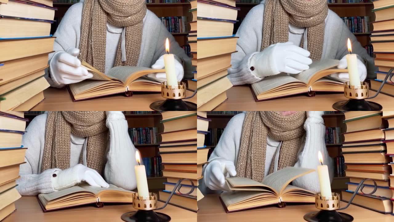 能源危机概念。缺乏暖气和电力照明。在图书馆使用蜡烛和保暖衣服阅读书籍裁剪人的视图。