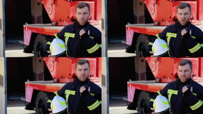 勇敢的消防员与背景消防车对讲机交谈。救人理念英雄职业消防安全