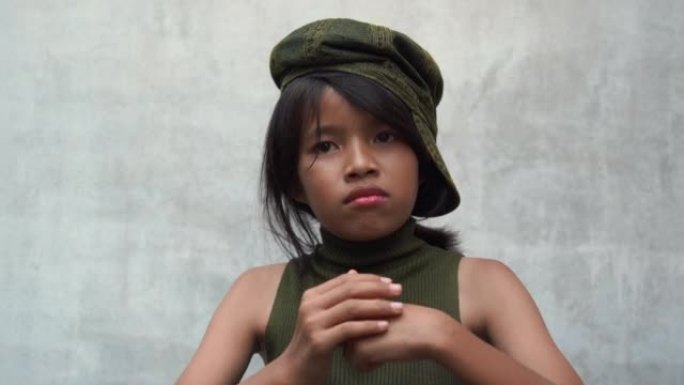 亚洲十几岁的潮女孩摆砸拳头的病毒视频在白色旧墙的背景