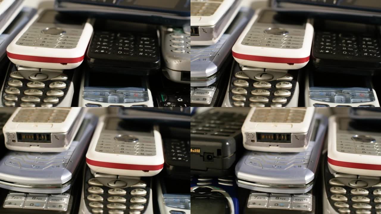 一堆带键盘的旧手机。多种类型和世代，再利用和回收电子废物的概念。