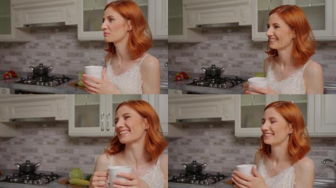 红发和黑发女性在厨房一起喝茶聊天。