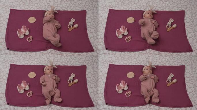 头上有蝴蝶结的女婴在毯子上放松