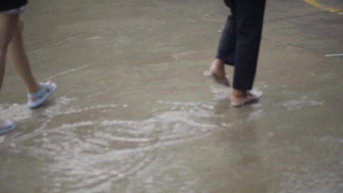 大雨中人们在洪水路上行走和奔跑