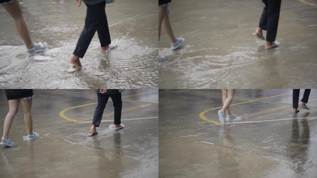 大雨中人们在洪水路上行走和奔跑