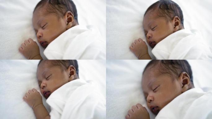 非洲快乐宝宝睡在床上的甜蜜梦特写肖像，白色背景，有复制空间。健康的新生儿睡个午觉。家庭爱新生儿保健医