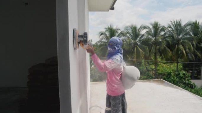 房屋油漆工与砂光机一起工作