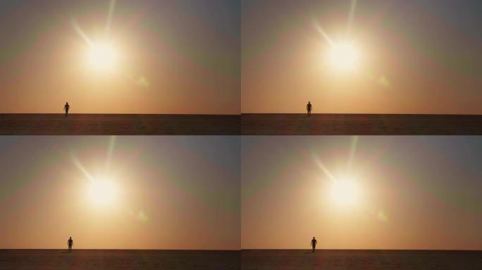 游客男性在沙漠中向后走日落的极宽镜头。