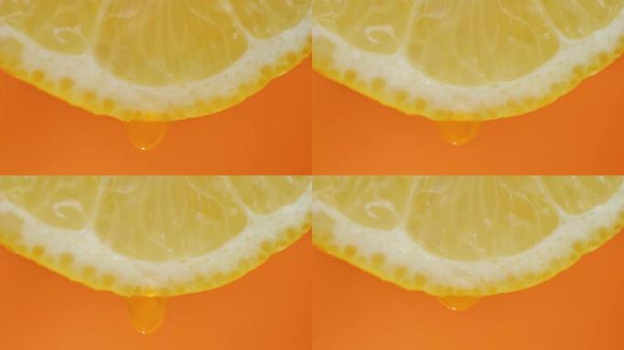 柠檬汁从果肉中流出，并在橙色背景上滴落，微距视频，慢动作
