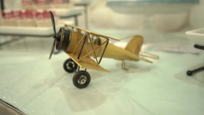 桌子上装饰的黄色玩具木制飞机的特写视图