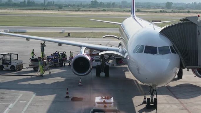 从客机上卸下飞机上的行李，并用连接在机翼上的管道加油。机场的行李和维修服务，慢动作