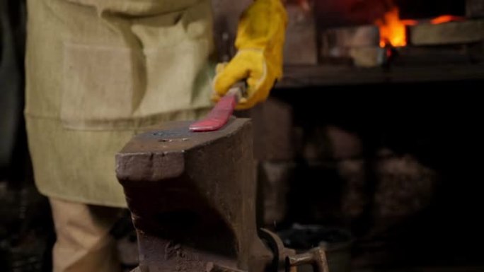 两个铁匠在铁砧上用铁锤敲打铁锤。