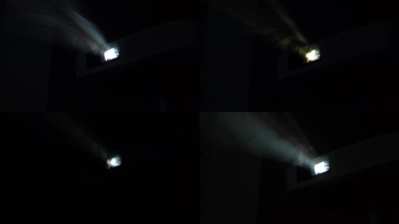 浓烟在聚光灯下发光。家用电影放映机照耀着浓密的蒸汽。烟光概念