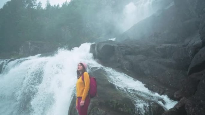挪威山区瀑布附近的女人徒步旅行