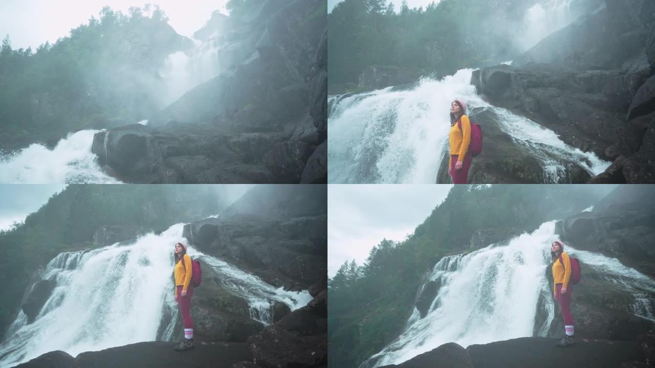 挪威山区瀑布附近的女人徒步旅行