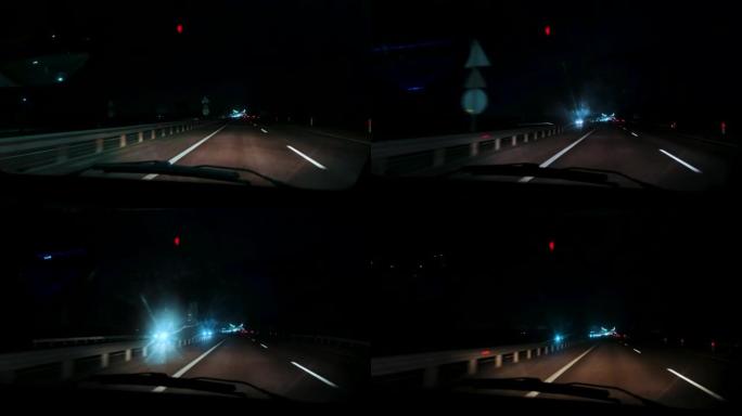 特写，夜间高速公路上行驶的汽车内部，通过挡风玻璃观看。模糊的道路，来自迎面而来的汽车前灯的bokeh