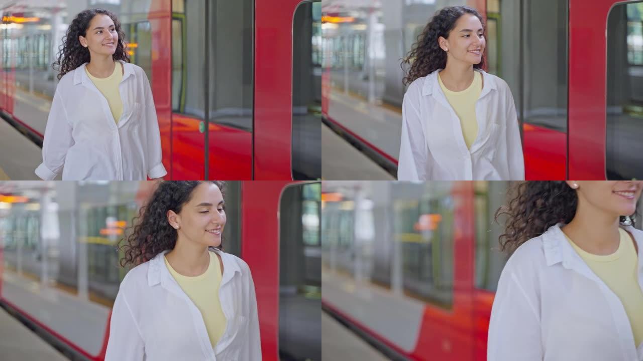 快乐微笑的女人正沿着新火车在空荡荡的铁路平台上行走，肖像女乘客