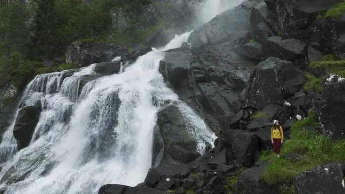 挪威山区瀑布附近徒步旅行的妇女的鸟瞰图