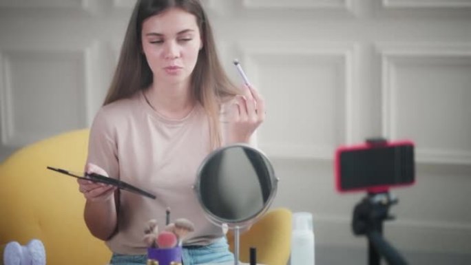 积极的女性美容博客在社交媒体上直播，十几岁的女孩正在教化妆