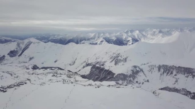 冬季日出时雪山岭的广阔空中全景。阴天滑雪胜地覆盖着雪粉的令人惊叹的山脉。格鲁吉亚-古达乌里的高加索山