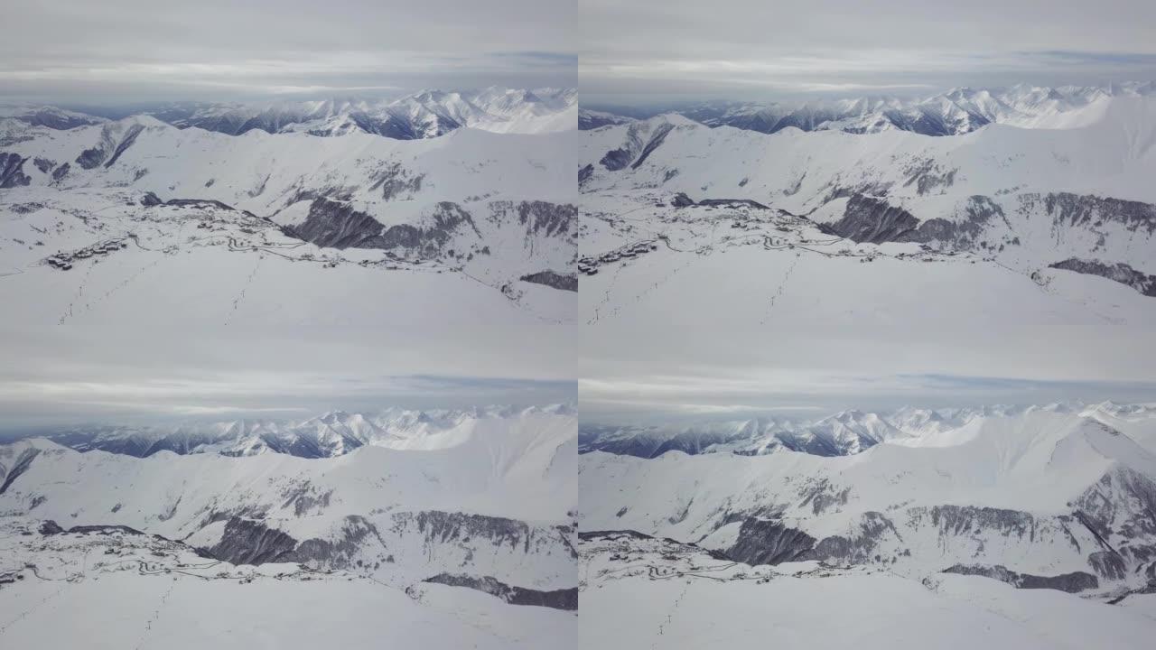 冬季日出时雪山岭的广阔空中全景。阴天滑雪胜地覆盖着雪粉的令人惊叹的山脉。格鲁吉亚-古达乌里的高加索山