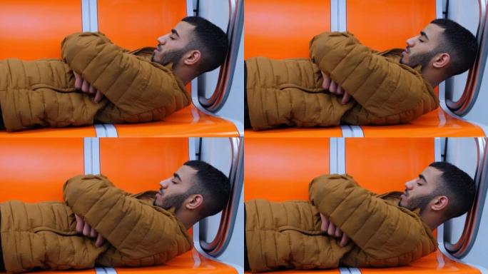 非常疲惫的北非年轻人在乘坐地铁时睡在火车上。一名突尼斯年轻人躺在地铁上睡觉