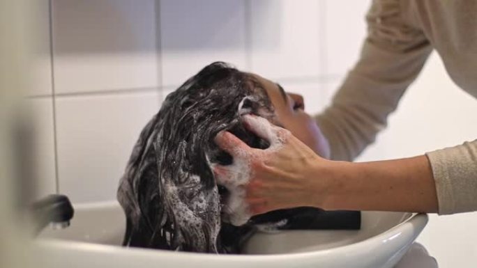 理发师洗客户的头发。