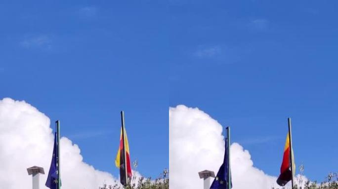 蓝天下的欧盟和德国国旗。欧洲的旗帜。收集旗帜。各国人民的友谊