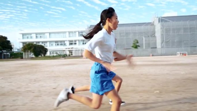 小学男女生在学校操场跑步