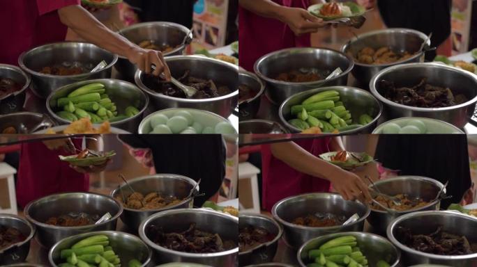 顾客在Nasi Jamblang菜单上吃油炸牛肺。西爪哇Cirebon的传统米饭。蒸米饭包裹在芬芳的