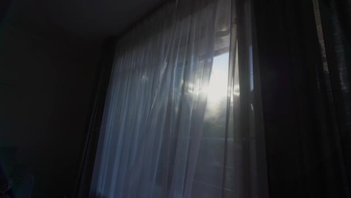 阳光透过悬挂在窗户上的透明白色窗帘