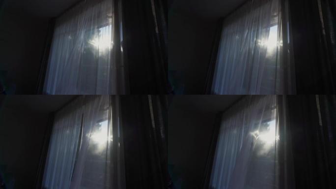 阳光透过悬挂在窗户上的透明白色窗帘