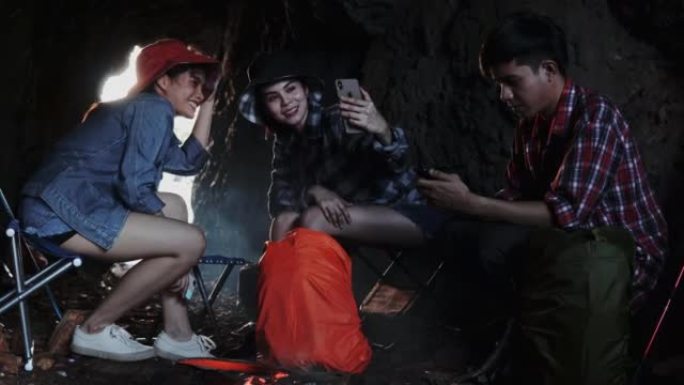 露营旅行期间，一群徒步旅行者攀爬朋友围坐在篝火旁，烤棉花糖