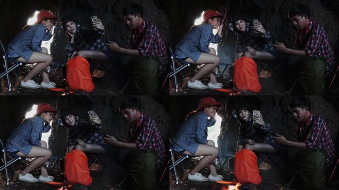 露营旅行期间，一群徒步旅行者攀爬朋友围坐在篝火旁，烤棉花糖
