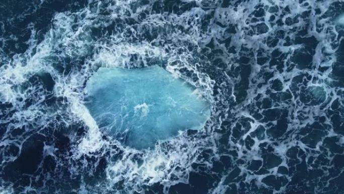 冰山巨大的蓝色冰块漂浮在海浪上海洋美丽的北极景观空中俯视图