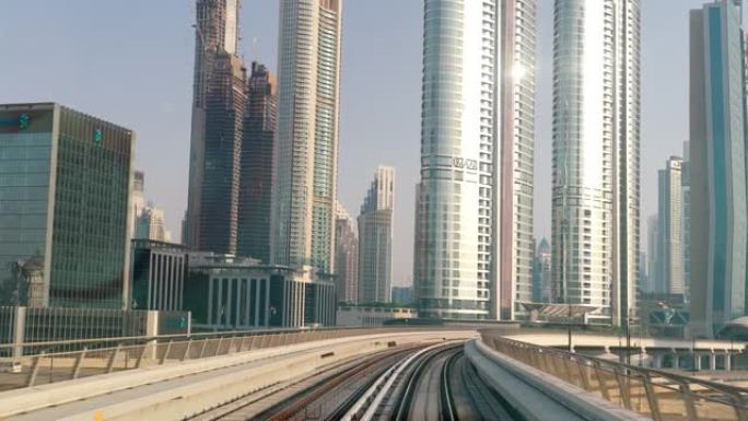阿联酋迪拜-2021年5月22日: 迪拜现代摩天大楼中的POV地铁列车。迪拜街道上的交通