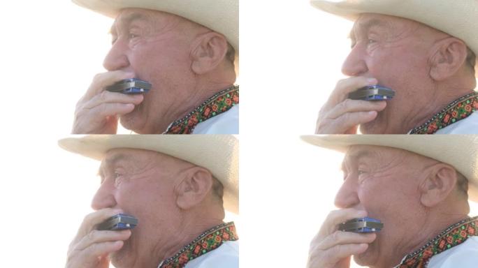 一个戴着帽子的老人吹口琴的脸的特写。