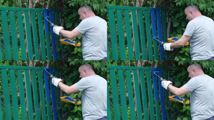 农村地区使用蓝色油漆的园丁绘画围栏