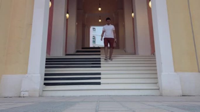 年轻的高加索游客在卡塔尔多哈的珍珠 (滨海中心) 豪华区的音乐台阶上行走，慢动作